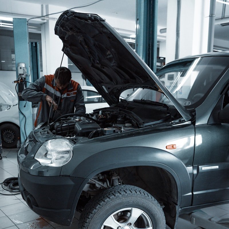 Mecânico realizando manutenção elétrica no motor do veículo